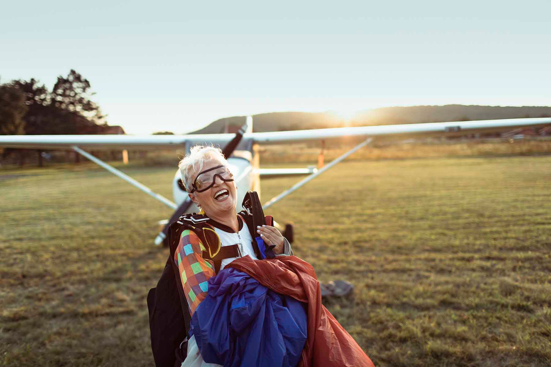 Close up of a senior skydiver next to a plane.