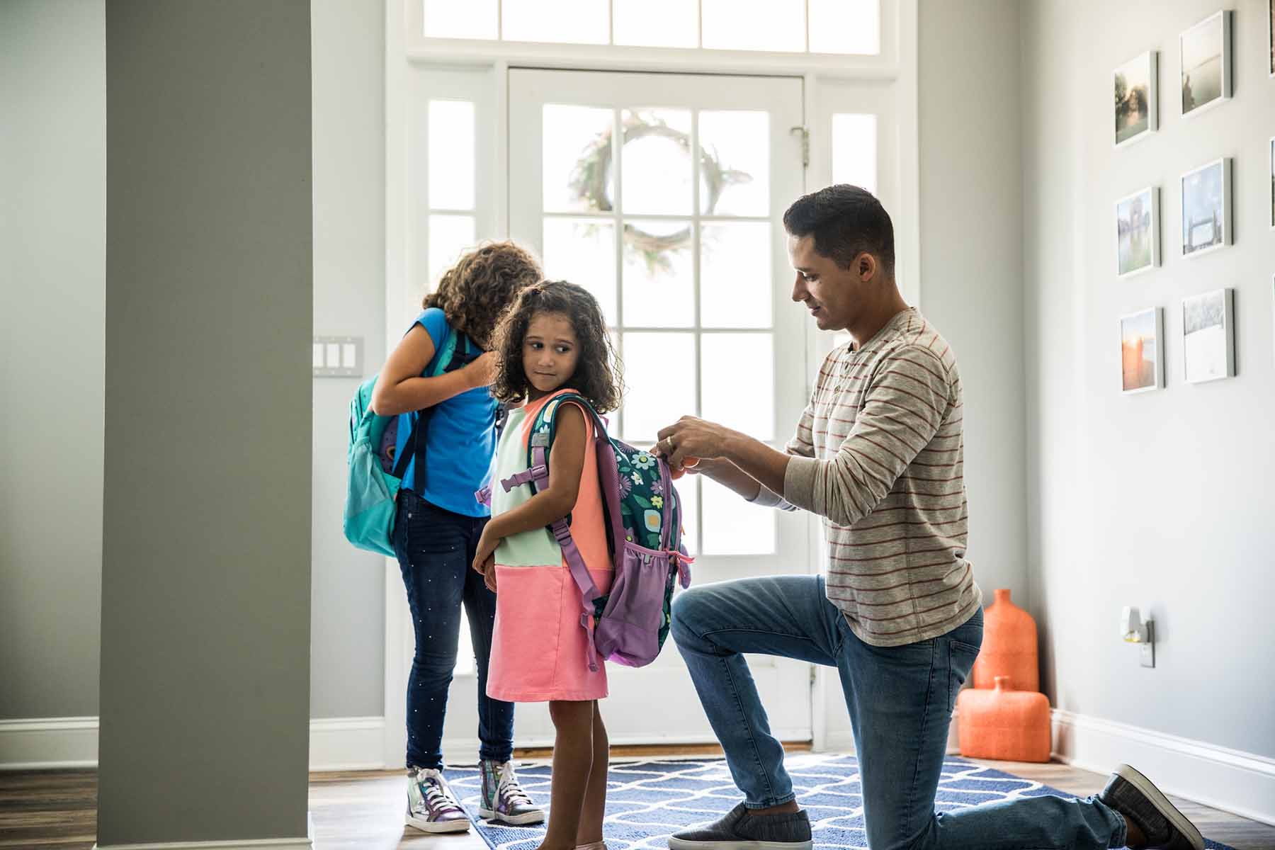 Father preparing young daughters for school