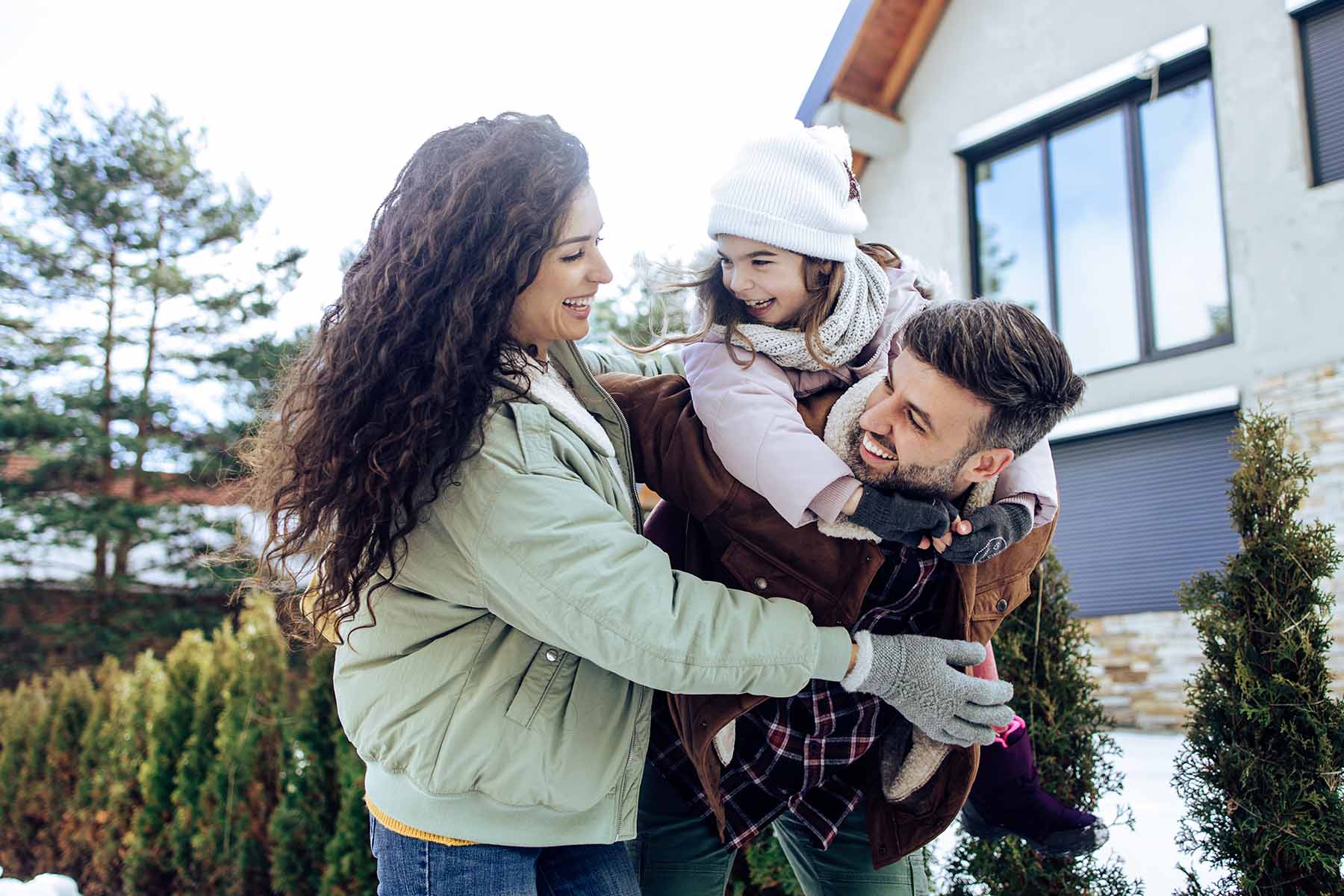 Family outside their home in winter