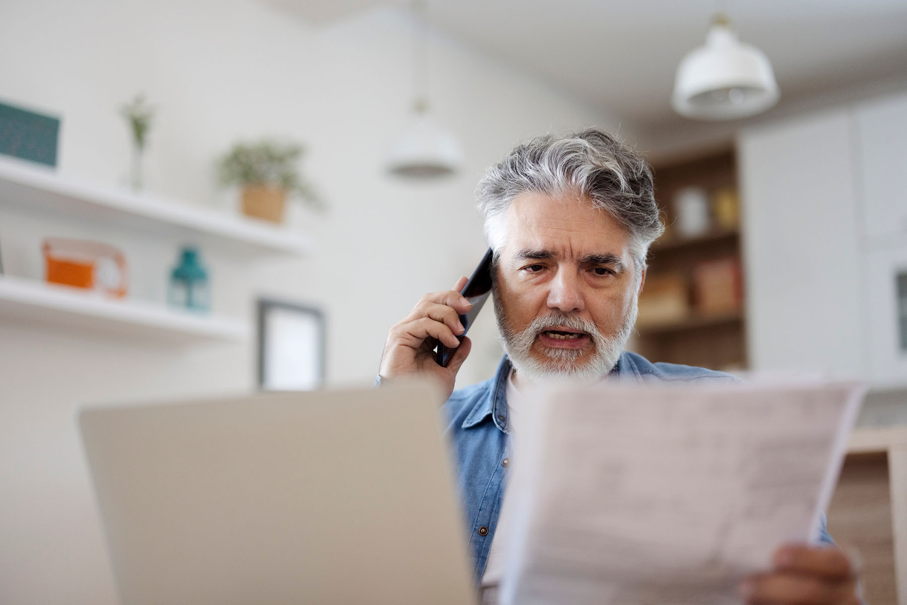 Man talking on phone looking at credit report