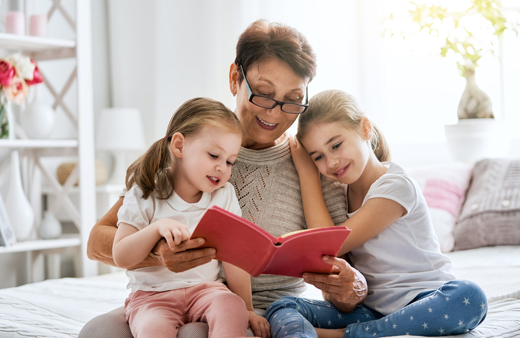 A grandmother reading to her two granddaughters