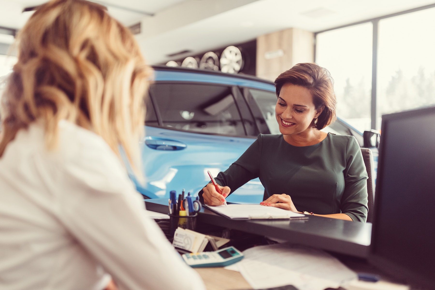 A woman fills out a loan application for a new car