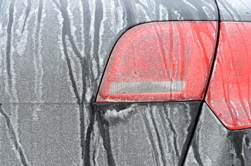 close up of car headlights coverd in icy snow