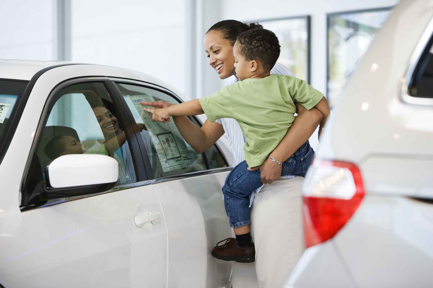 Woman and son looking at car's sticker price