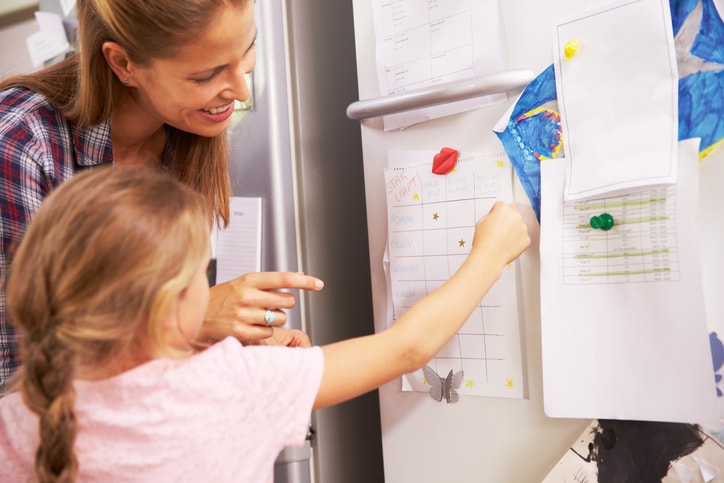 mother and kid with calendar on fridge door