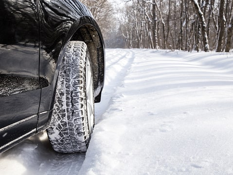 car driving in snow image is close up of car tire