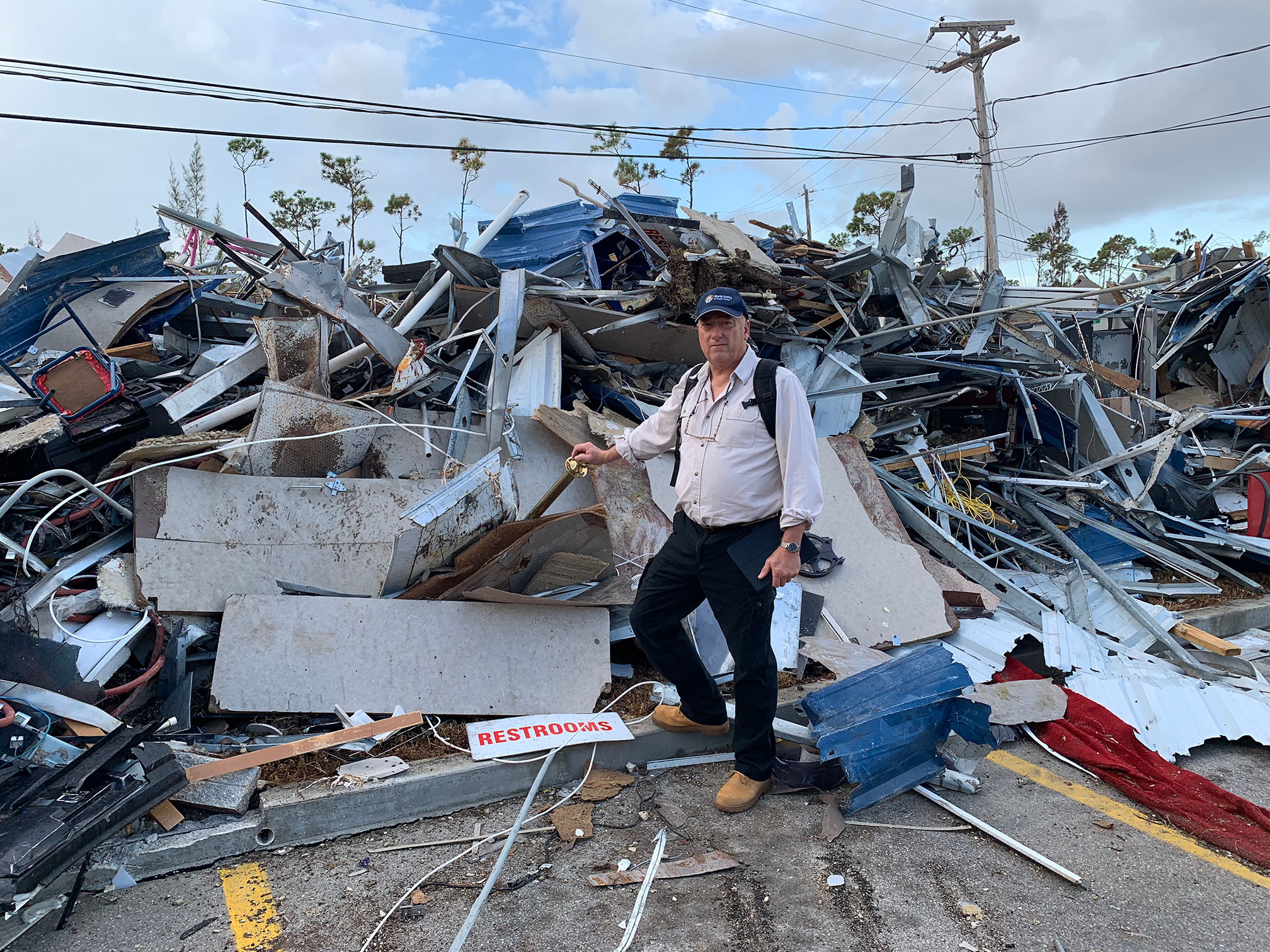 Amiercan Heritage President and CEO, Bruce K. Foulke standing next to rubble of building