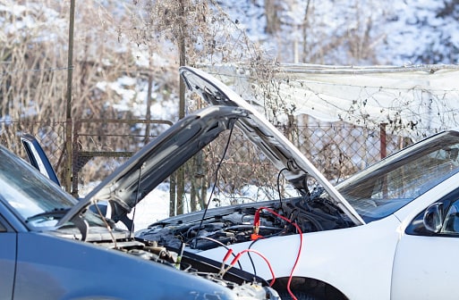 two cars connected by jumper cables