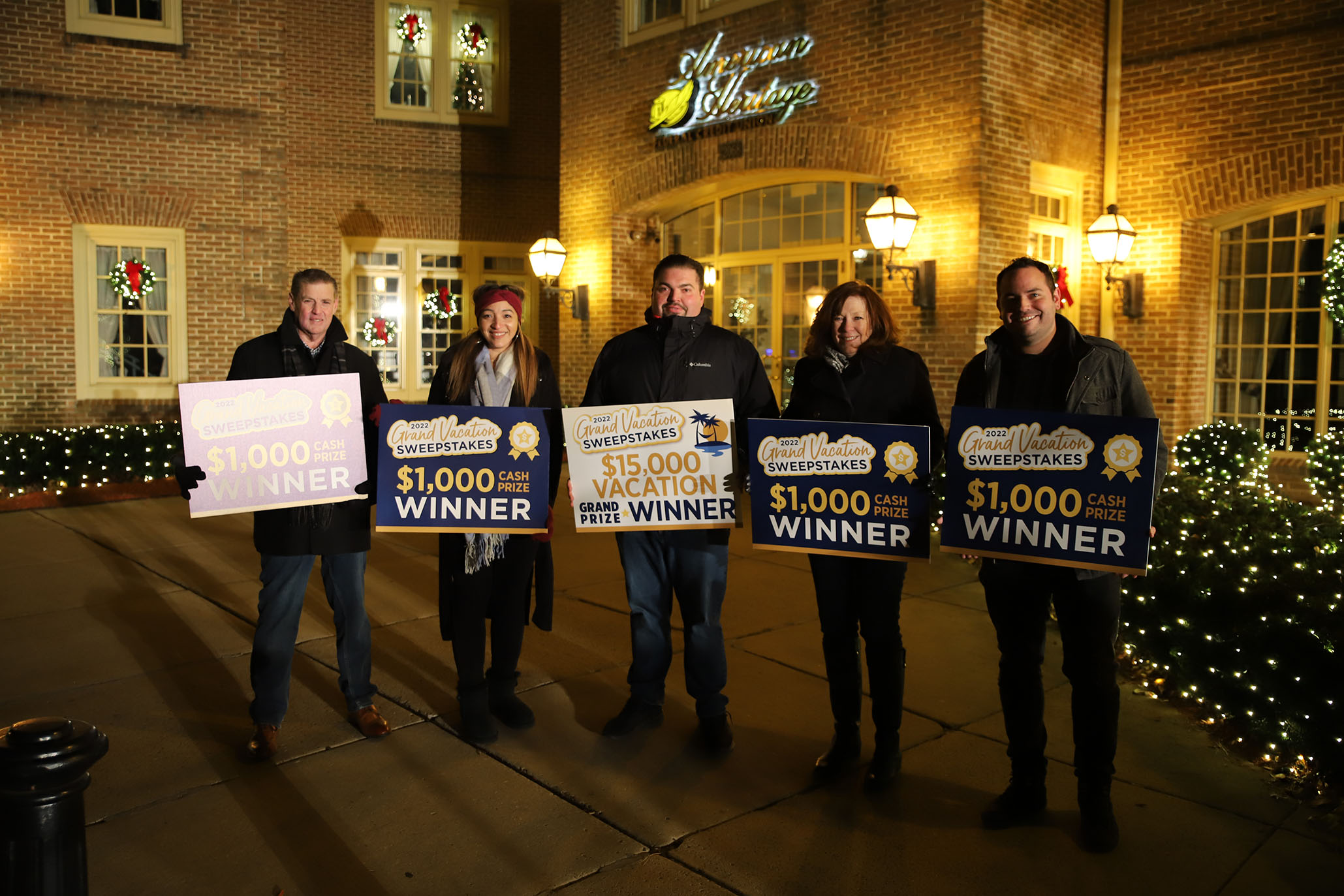 The five finalist of the Grand Vacation Sweepstakes stand together displaying their amount won.