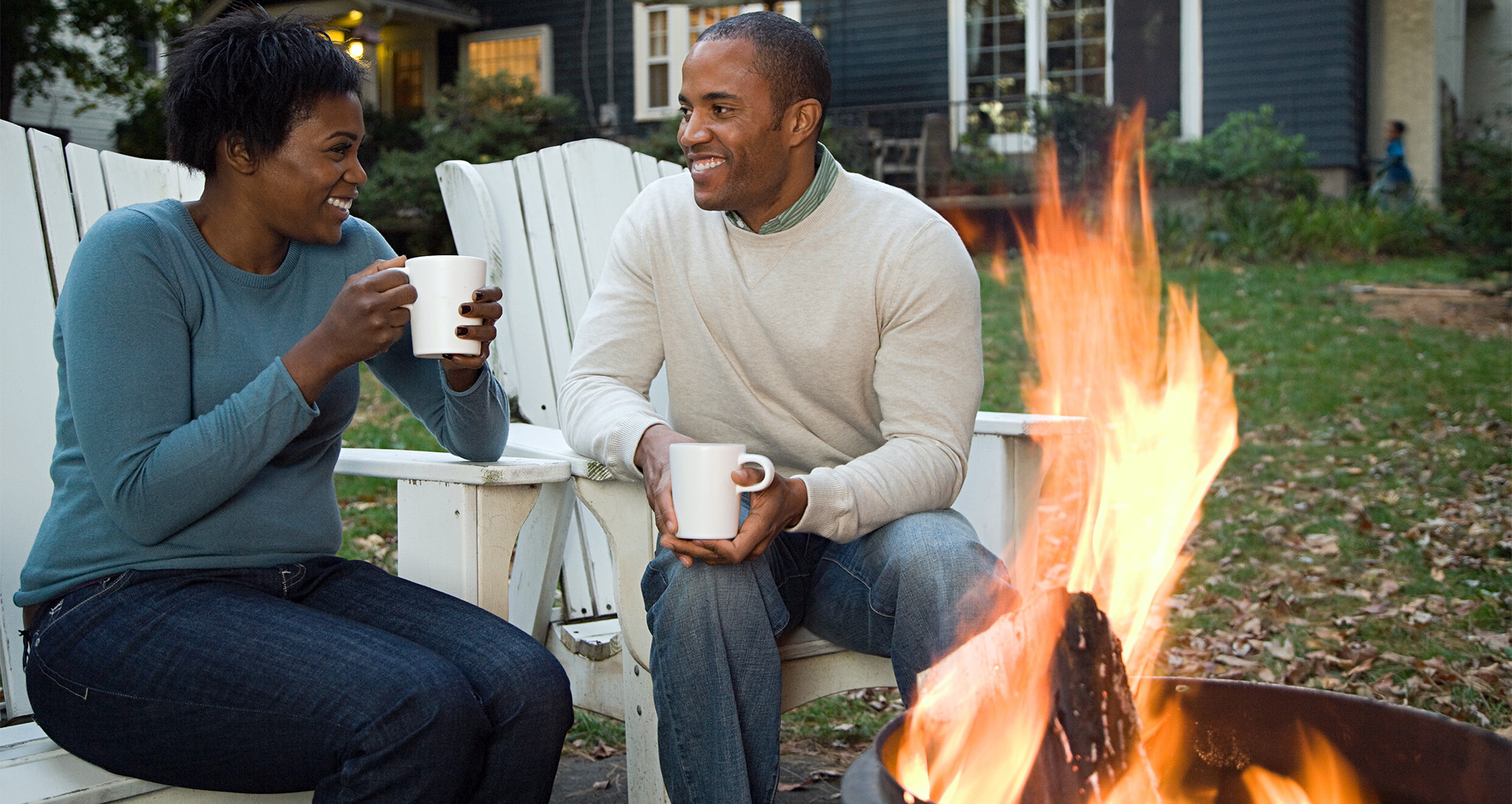 couple sitting in their backyard near a firepit