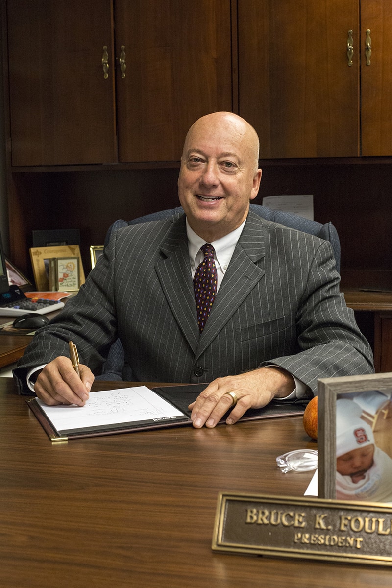 Our President/CEO, Bruce K. Foulke sitting at his office desk