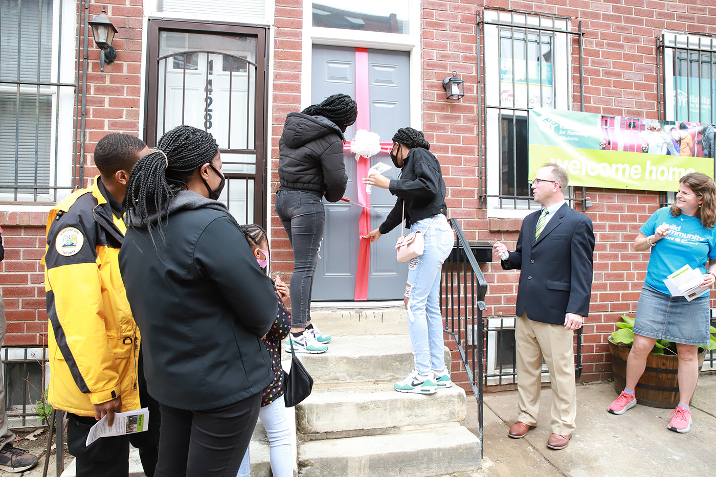 American Heritage Credit Union’s Senior Vice President of Marketing (right) presents Habitat for Humanity partner family with the keys to their new home.