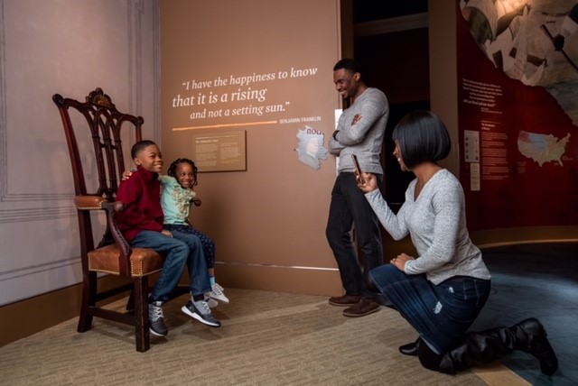 Mother takes photo of her 2 children at the Museum