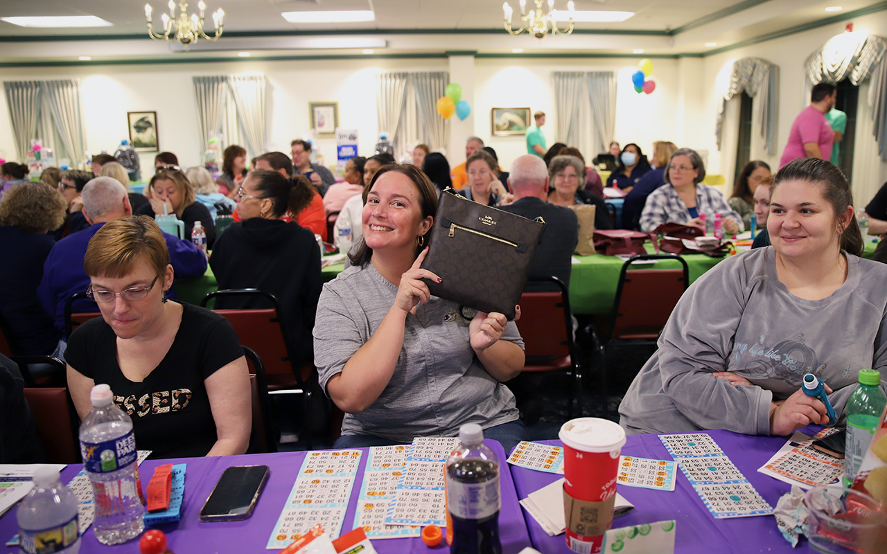 Winner from the Kids-N-Hope Foundation’s Purse and Power Tool Bingo holding designer purse.