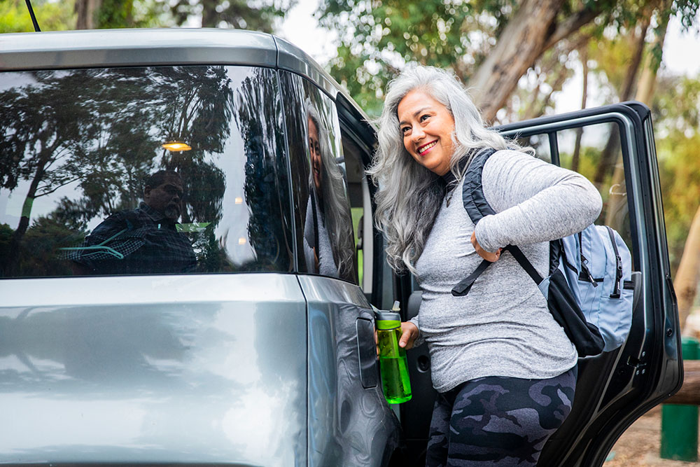 woman sitting in her car in a flannel